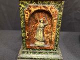 an image of a statue of a woman holding a bird on a pedestal