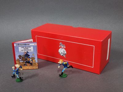 des figurines représentant deux hommes en uniforme bleu et une boîte rouge