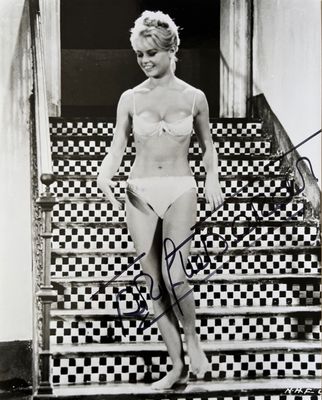 an old photo of a woman in a bikini standing on a set of stairs
