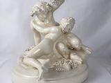 une statue représentant une femme et un enfant assis sur une table