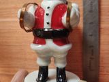 une petite figurine représentant le Père Noël tenant une clochette