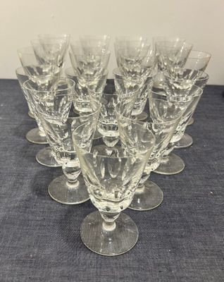 six verres à vin transparents posés sur une table bleue