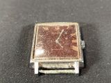 a small square watch sitting on top of a table