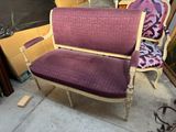 fauteuil rembourré violet devant un tas de bric-à-brac