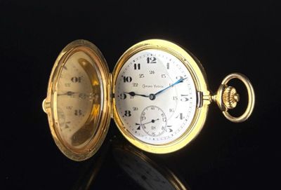 gros plan d'une montre de poche sur une surface noire