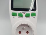 a white electronic device with a green button on it