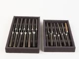 two black and silver chopsticks in a black box on a white background