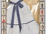 une poupée dans une boîte, vêtue d'une robe et chaussée de souliers
