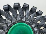 a green bowl sitting on top of a black wicker basket