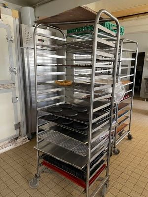 many trays of food that are on a metal rack