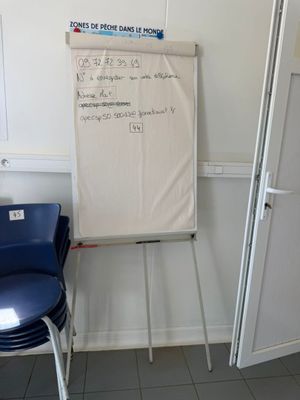 a white board on the wall next to a blue chair