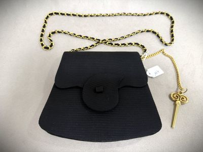 an image of a black purse with a gold chain and a key