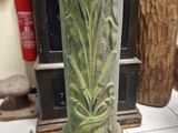 a close up of a green vase on a tile floor