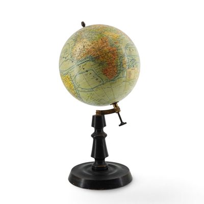 a small globe that is on a stand on a white surface