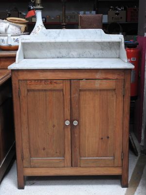une armoire en bois surmontée d'un lavabo en marbre
