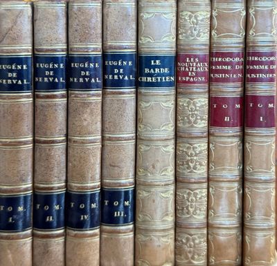 several old books are lined up on a shelf in a library