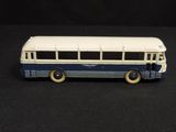 a blue and white bus that is on a black surface