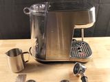 a coffee maker and measuring cups on a table