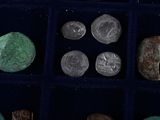 several different types of coins are in a display case on a table
