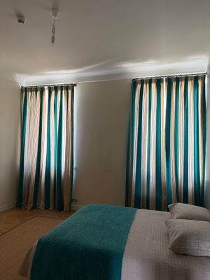 une chambre avec un grand lit et une télévision à écran plat accrochée au mur