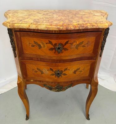 a small chest of drawers with a marble top