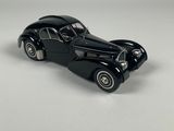 a black toy car sitting on top of a white surface
