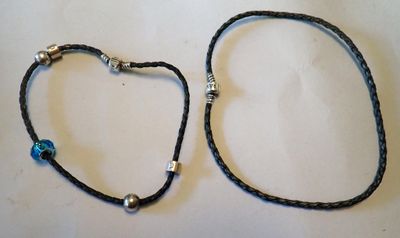 paire de bracelets en cuir noir ornés de perles argentées et d'une perle bleue