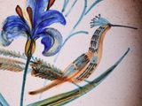a painting of a bird and a flower on a wall