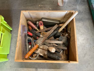 a box full of hammers and other tools sitting on the floor