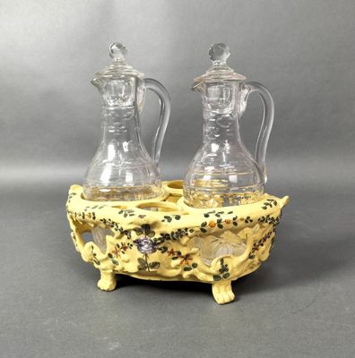 paire de vases jaunes avec couvercles en verre, posés sur un socle, sur fond gris