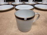 several cups and saucers are lined up on a table