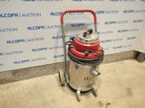 the vacuum is sitting on the floor next to the wall