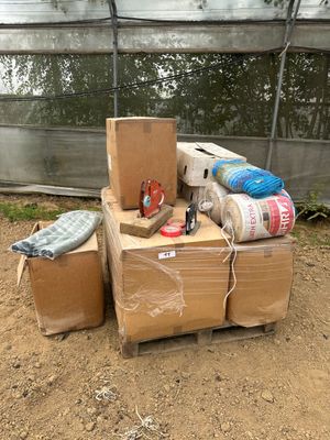 une pile de cartons posée par terre devant une serre