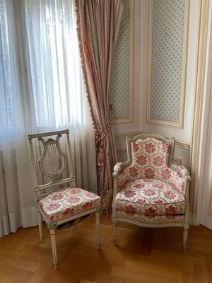 two chairs in the corner of a room near a window