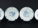 quatre assiettes bleues et blanches ornées de fleurs sur fond noir