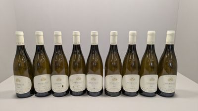 six bouteilles de vin blanc sont alignées sur une table
