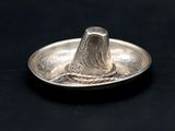 a silver coin with a bird on it on a black surface