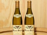 deux bouteilles de vin posées sur un tonneau