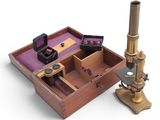 a wooden box with a microscope and other items in it