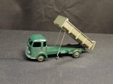 a green toy truck with a dump truck attached to it