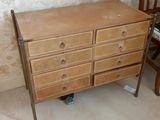 une commode et une chaise en bois dans une pièce dont l'un des murs est tapissé