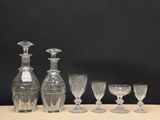five wine glasses and a decanter on a table