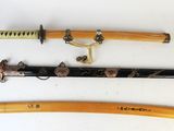 Trois types différents de sabres japonais sont exposés sur un fond blanc