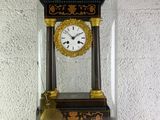 une petite horloge sous un dôme de verre sur une table