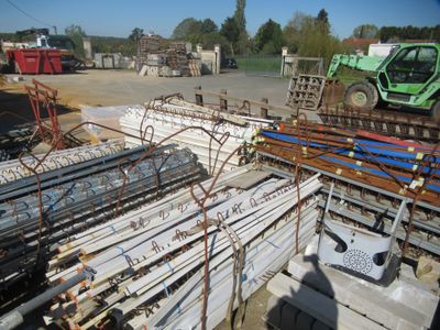 un gros tas de barres et de poteaux en acier dans une cour