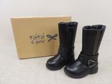 two pairs of black leather boots with buckles and a box in the background