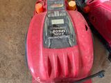 a red blower sitting on the floor next to other items
