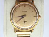 wrist watch on display with white fabric and gold metal band