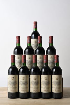 six bottles of wine sit on a wooden table in front of a white wall