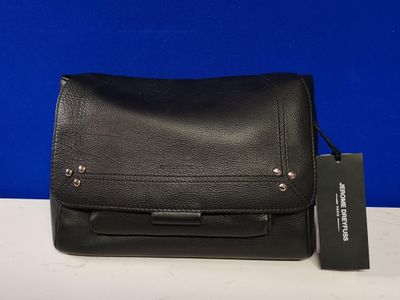 un sac à main noir muni d'une étiquette, posé sur une table